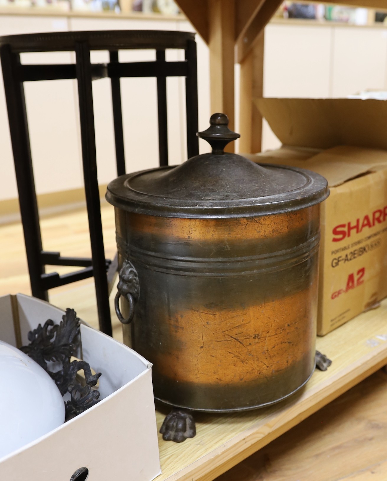 Benares brass folding table on wooden stand, 52cm tall, together with a three-footed lion pawed coal bucket and cover